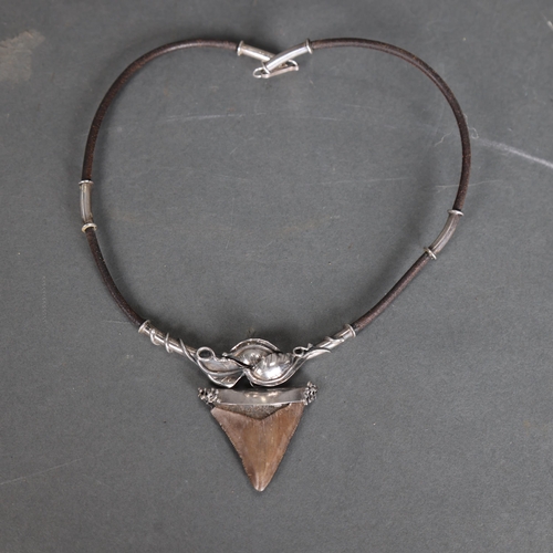 3333 - A leather and silver mounted necklace with Megalodon Sharks tooth pendant, tooth is 4cm in length.