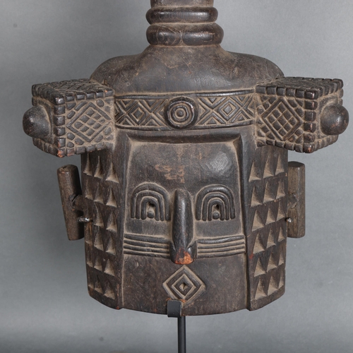 3471 - An African tribal carved wood mask mounted on metal stand, height 67cm.