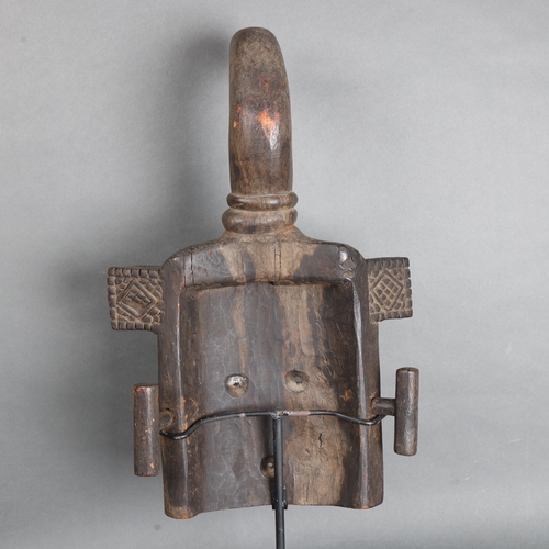 3471 - An African tribal carved wood mask mounted on metal stand, height 67cm.