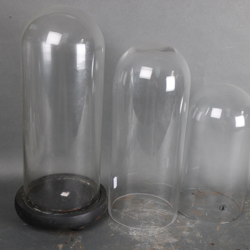 3495 - Three circular glass domes, one with turned wood base, dome with base, overall height 38cm, diameter... 