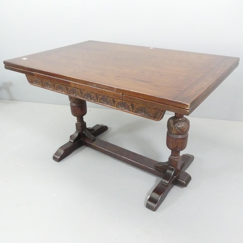 2347 - A reproduction oak draw-leaf dining table, raised on baluster turned legs and having carved decorati... 