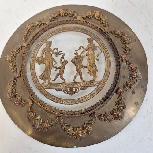 247 - An Antique circular brass and glass plaque, with applied swag and rose decoration and Grecian figure... 