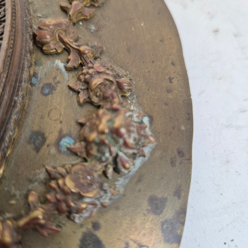 247 - An Antique circular brass and glass plaque, with applied swag and rose decoration and Grecian figure... 