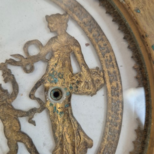 247 - An Antique circular brass and glass plaque, with applied swag and rose decoration and Grecian figure... 