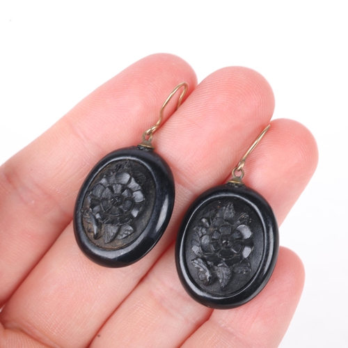 1115 - A pair of Victorian Whitby Jet drop earrings, relief carved floral decoration, with shepherd hook fi... 