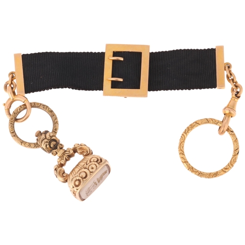 1121 - An Antique 15ct gold black silk watch fob chain, with hardstone intaglio seal fob and foliate split ... 