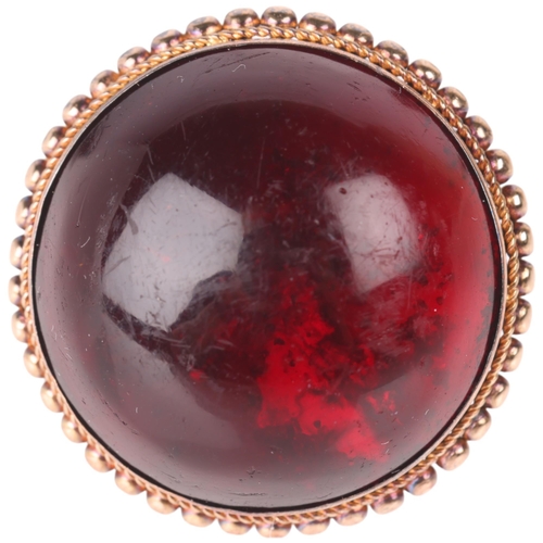 1142 - An Antique 9ct gold garnet dress ring, set with foil-back round cabochon garnet within beaded edge c... 