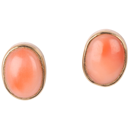 1146 - A pair of 9ct gold coral stud earrings, rub-over set with oval cabochon coral, 9mm, 1.9g