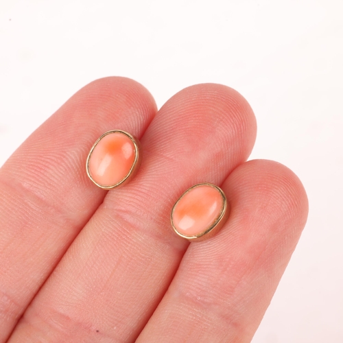 1146 - A pair of 9ct gold coral stud earrings, rub-over set with oval cabochon coral, 9mm, 1.9g