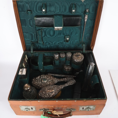 1609 - A late Victorian tan leather travelling vanity case, containing various silver fittings, including h... 