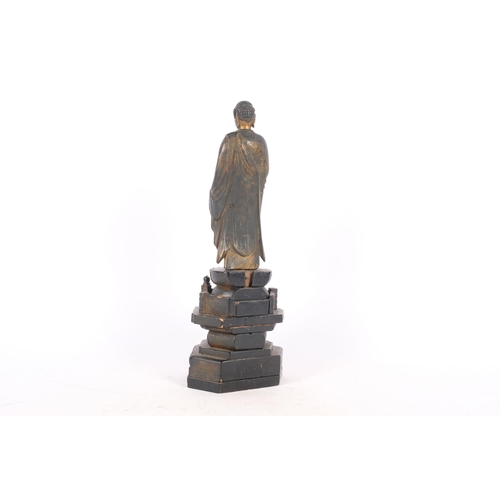 184 - Meiji period, a carved and partial gilt figure of a buddha on pagoda stand, height 34cm