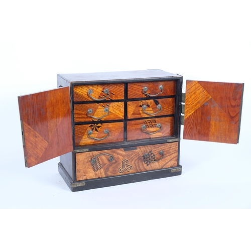 40 - A Japanese Meiji Period lacquered specimen wood kodansu table-top cabinet, circa 1910, the abalone a... 