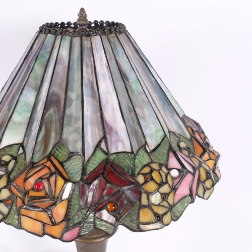 429 - An embossed brass table lamp, with Tiffany style leadlight shade with floral frieze, H58cm