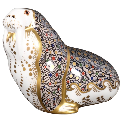 642 - A Royal Crown Derby porcelain walrus paperweight, with gold button, H11cm