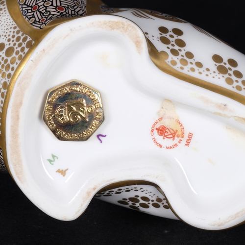 642 - A Royal Crown Derby porcelain walrus paperweight, with gold button, H11cm