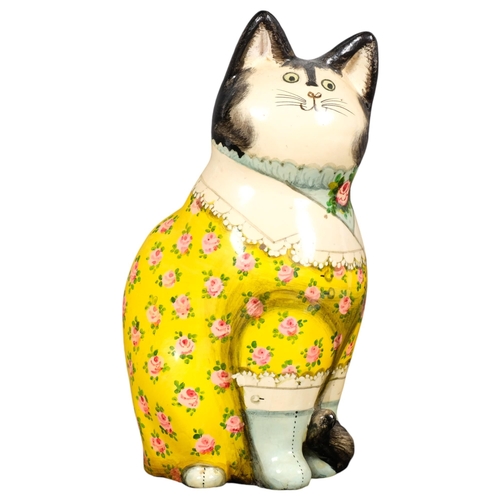 644 - JOAN & DAVID DE BETHEL - a painted papier mache seated cat figure, decoupage style decoration with b... 