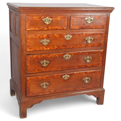 173 - An 18th century oak chest of drawers, with walnut feather banded drawer fronts panelled sides and br... 