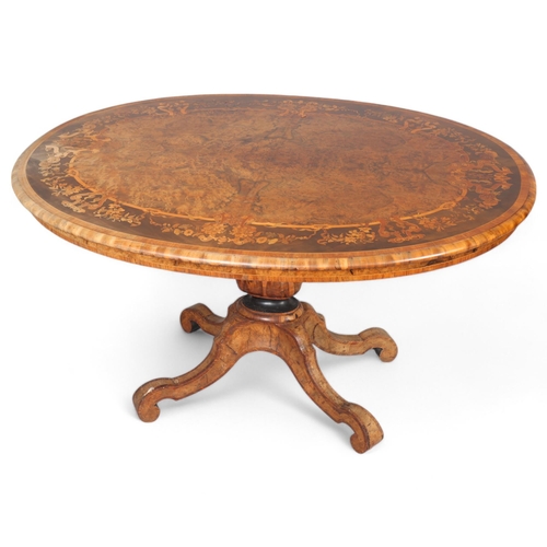 175 - A Victorian burr walnut oval tilt-top dining table, intricate marquetry inlaid top on carved quadrup... 