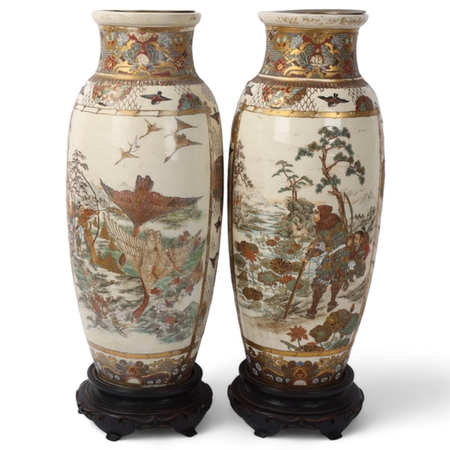 219 - A pair of Japanese Satsuma porcelain vases, with painted and gilded warriors, on carved wood stands,... 