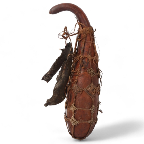 227 - An African Tribal witch doctor's gourd and accoutrements, length 43cm