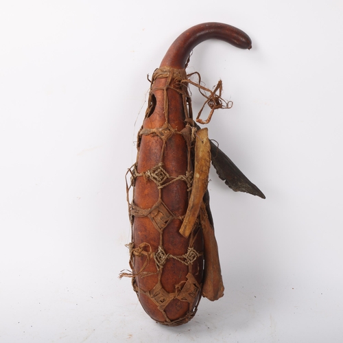 227 - An African Tribal witch doctor's gourd and accoutrements, length 43cm