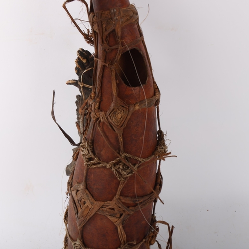 227 - An African Tribal witch doctor's gourd and accoutrements, length 43cm