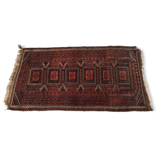 287 - An Antique Persian red ground Beluchi wool rug, with central Union Jack panels, 155cm x 87cm