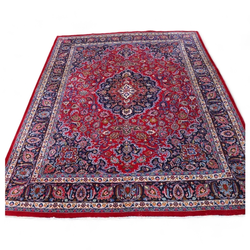 292 - A large Middle Eastern Kashan red ground wool rug, 383cm x 294cm