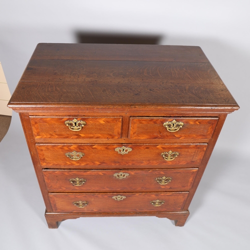 173 - An 18th century oak chest of drawers, with walnut feather banded drawer fronts panelled sides and br... 