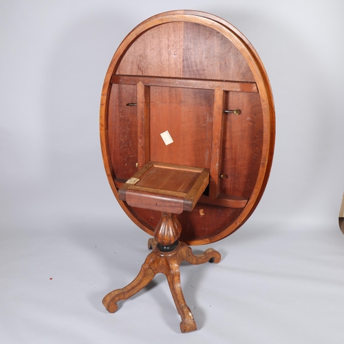 175 - A Victorian burr walnut oval tilt-top dining table, intricate marquetry inlaid top on carved quadrup... 