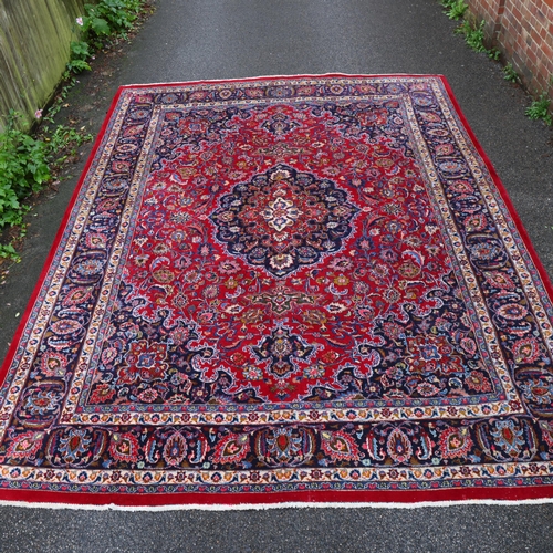 292 - A large Middle Eastern Kashan red ground wool rug, 383cm x 294cm