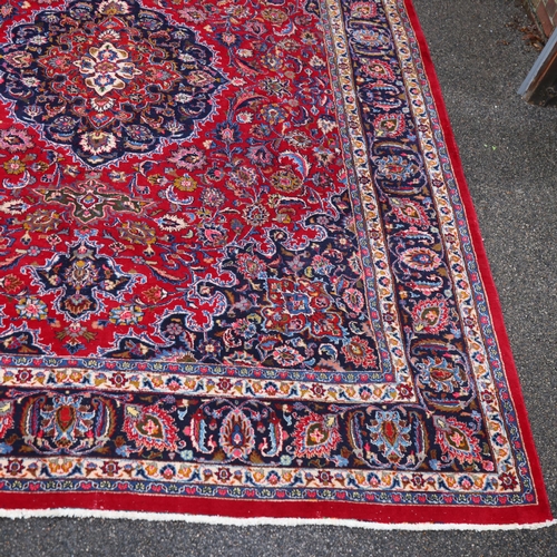 292 - A large Middle Eastern Kashan red ground wool rug, 383cm x 294cm