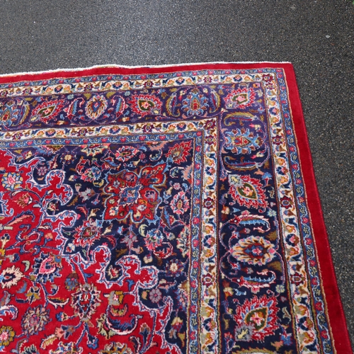 292 - A large Middle Eastern Kashan red ground wool rug, 383cm x 294cm