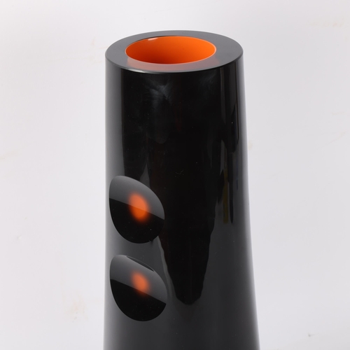 421 - JAN BERANEK for Sklo, a heavy walled black glass vase with orange lining and cut out detail, signed ... 