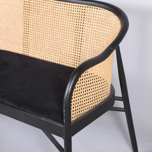 453 - An ebonised bentwood sofa, with caned back and brass feet, in the manner of Thonet,  L103cm