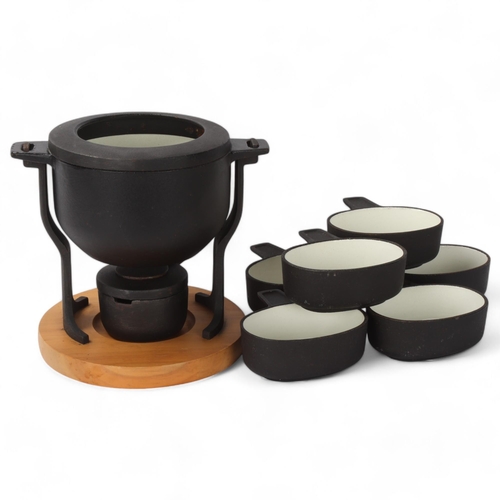 490 - Digsmed Design, Denmark, a cast iron fondue set with white enamel interior and beech wood base, make... 