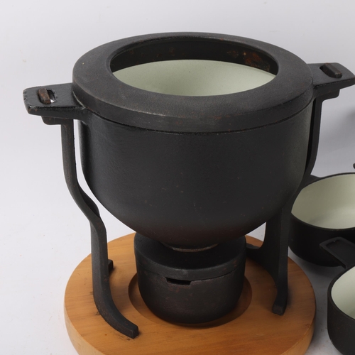 490 - Digsmed Design, Denmark, a cast iron fondue set with white enamel interior and beech wood base, make... 