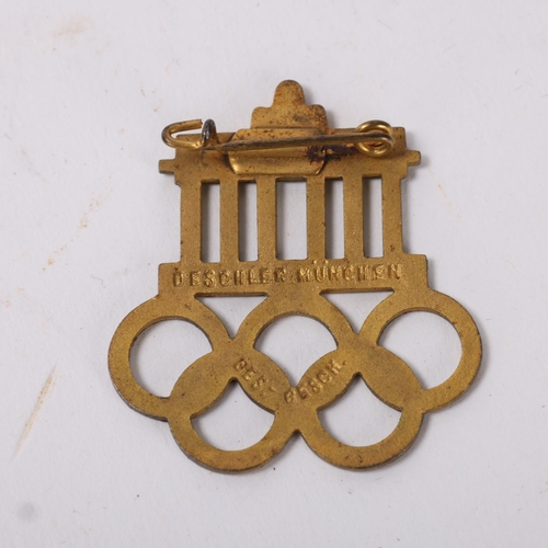 82A - A 1936 Berlin Olympics visitors badge,  base metal with gilt finish and infilled with white enamel m... 