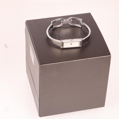 1052 - GUCCI - a lady's stainless steel 1500L quartz bangle watch, circa 2000, silvered dial with dauphine ... 