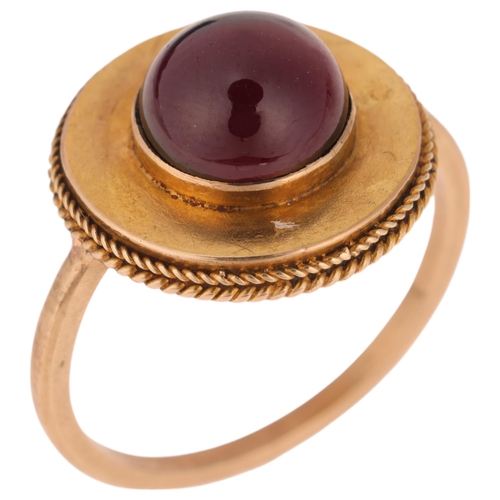 1119 - An Antique Victorian Etruscan Revival garnet mourning ring, circa 1880, centrally set with foil-back... 