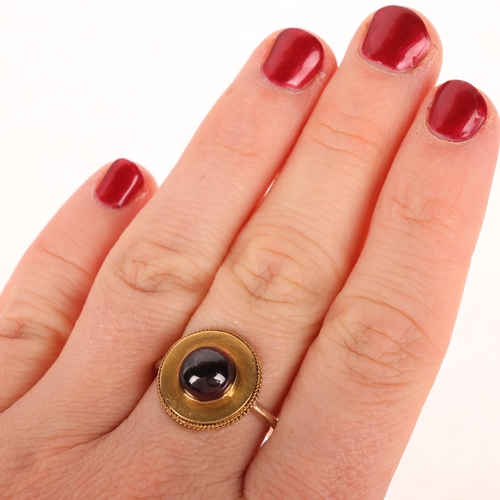 1119 - An Antique Victorian Etruscan Revival garnet mourning ring, circa 1880, centrally set with foil-back... 