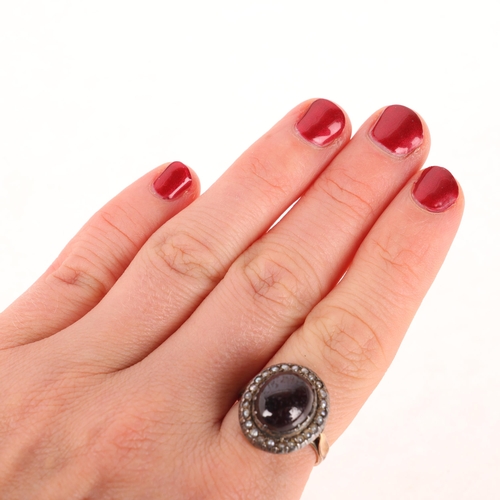 1135 - A Victorian garnet and pearl cluster mourning ring, circa 1880, centrally cut-down collet set with f... 