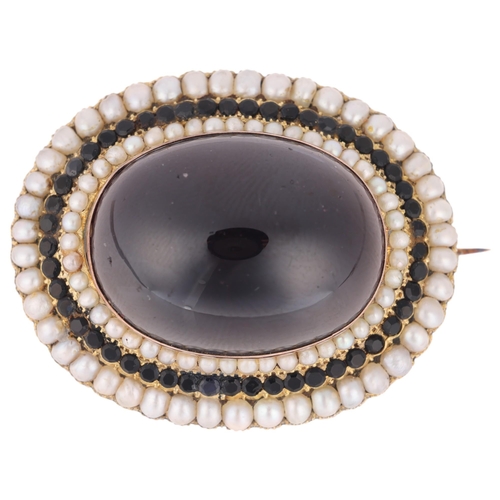 1136 - A large Victorian garnet and split pearl mourning brooch, centrally rub-over set with large foil-bac... 