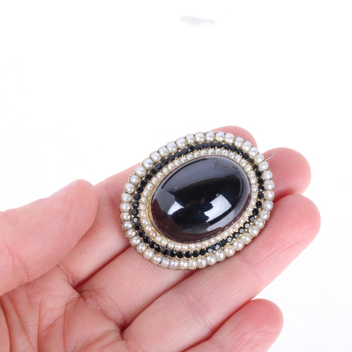 1136 - A large Victorian garnet and split pearl mourning brooch, centrally rub-over set with large foil-bac... 