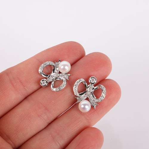 1187 - A pair of 18ct white gold whole pearl and diamond ribbon bow stud earrings, each set with 6mm pearl ... 