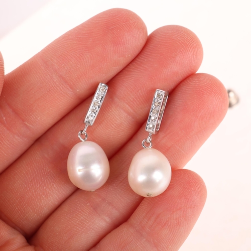 1214 - A pair of 18ct white gold pearl and diamond drop stud earrings, each set with 11.7mm pearl, suspende... 