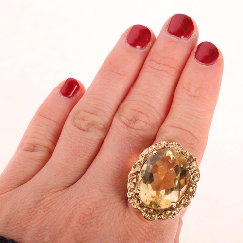 1249 - A large 9ct gold citrine dress ring, maker LGH, set with oval mixed-cut citrine within relief foliat... 