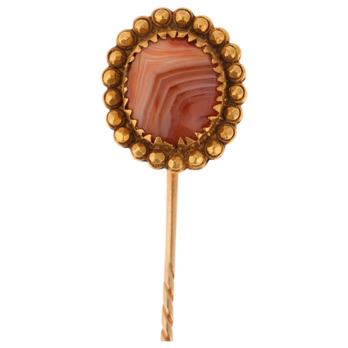 1257 - An Antique Victorian 14ct gold banded agate stickpin, set with round cabochon agate within beaded su... 