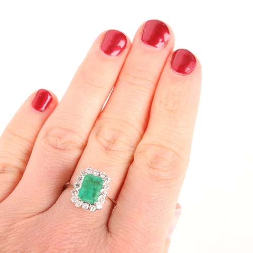 1285 - An 18ct white gold emerald and diamond cluster ring, set with octagonal step-cut emerald and modern ... 