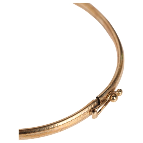 1302 - A 9ct gold hinged bangle, band width 3.5mm, internal circumference 17cm, 3.3g